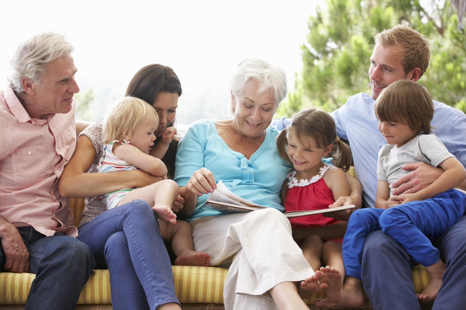 multi-generational family sitting together reading a book