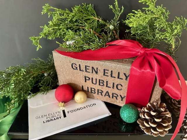 red brick with red ribbon and holiday greenery